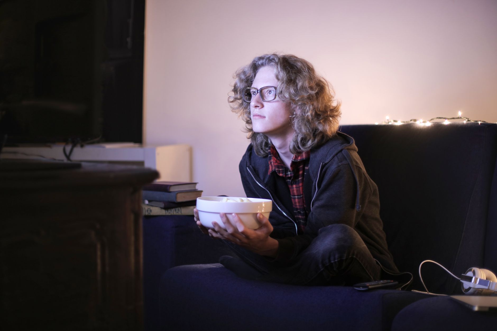 person watching thriller movie alone dark room