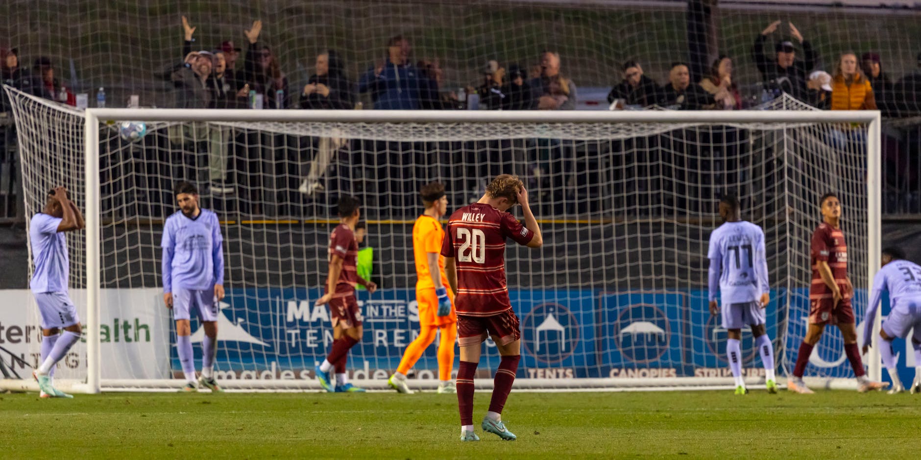 football players celebrating goal on stadium pitch