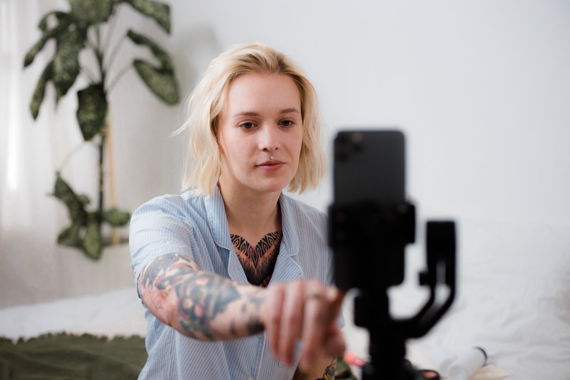 male content creator filming video with smartphone tripod