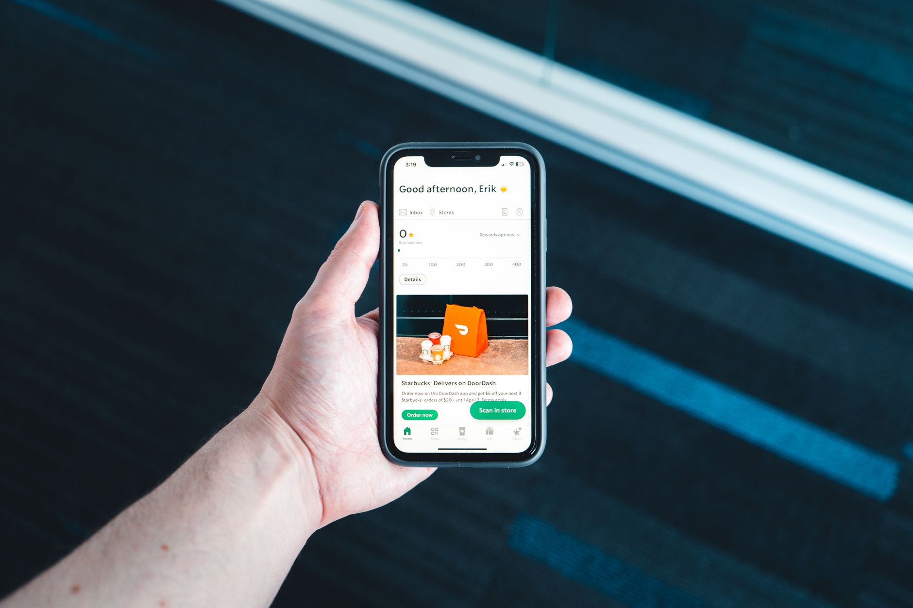 Hand holding smartphone showing electricity app screen