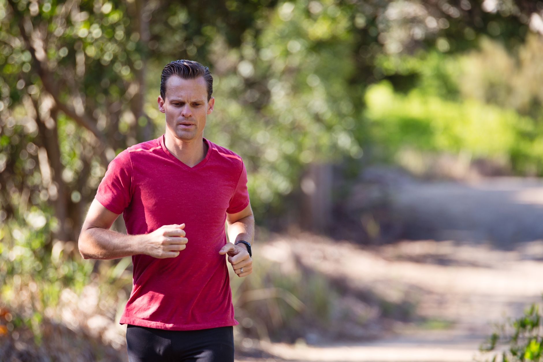 person jogging in green park early morning wearing smartwatch
