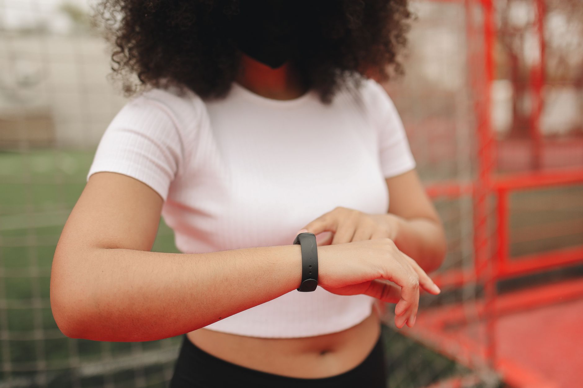 runner checking smartwatch on wrist green park