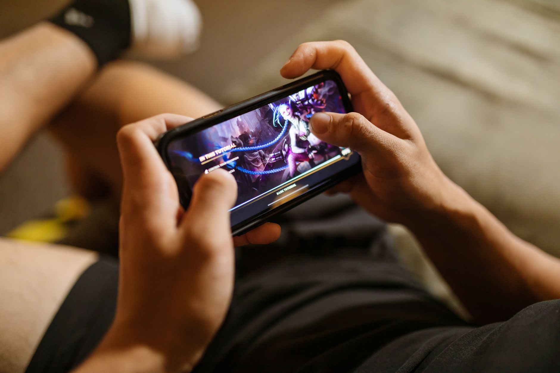 hand holding gaming smartphone playing mobile game