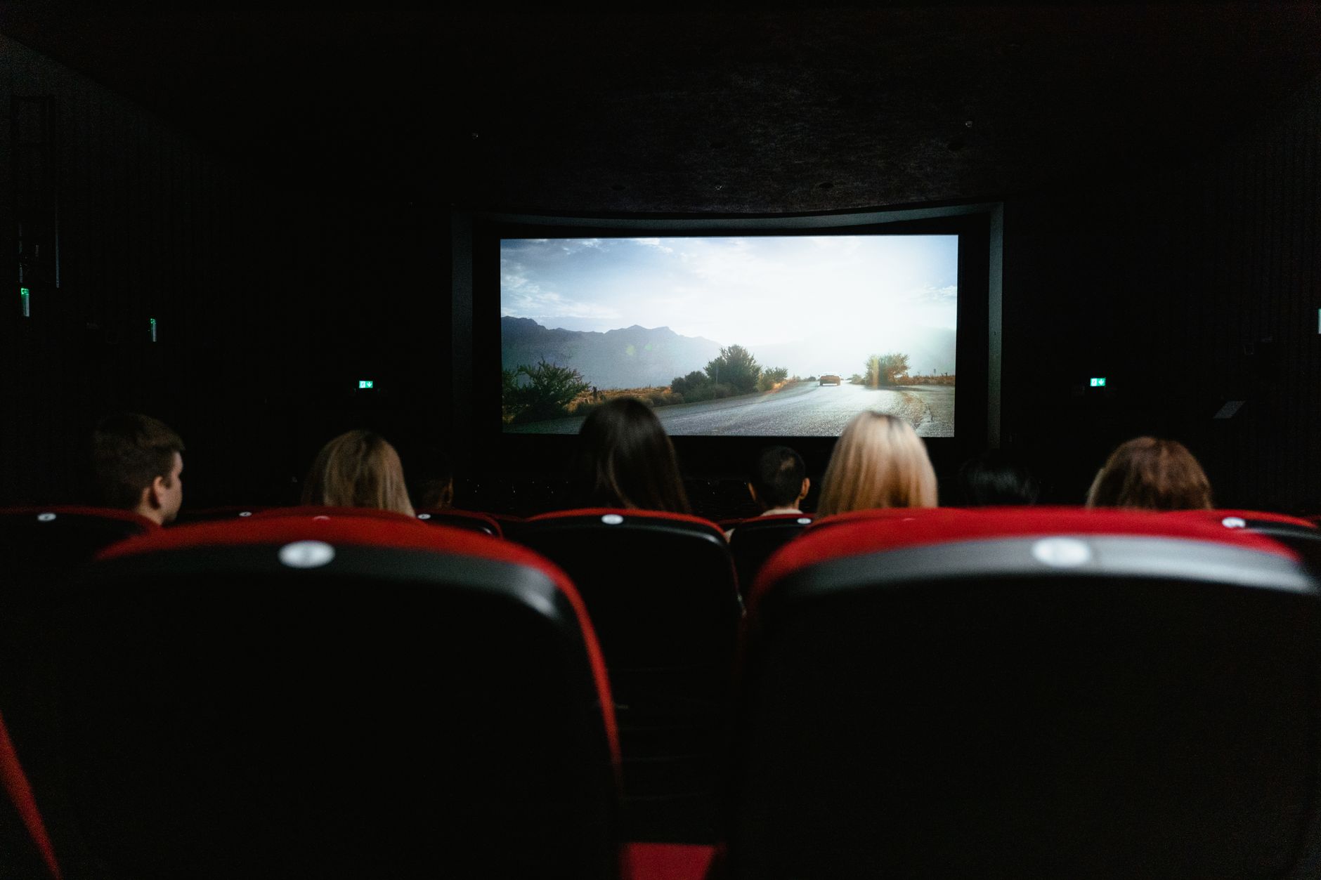children audience watching animated film in dark cinema