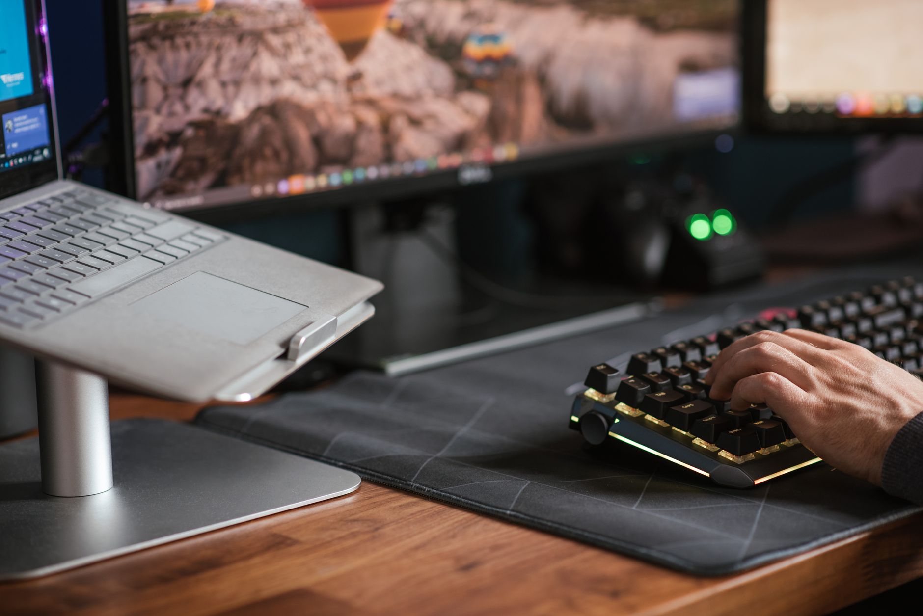 person typing on laptop keyboard in office