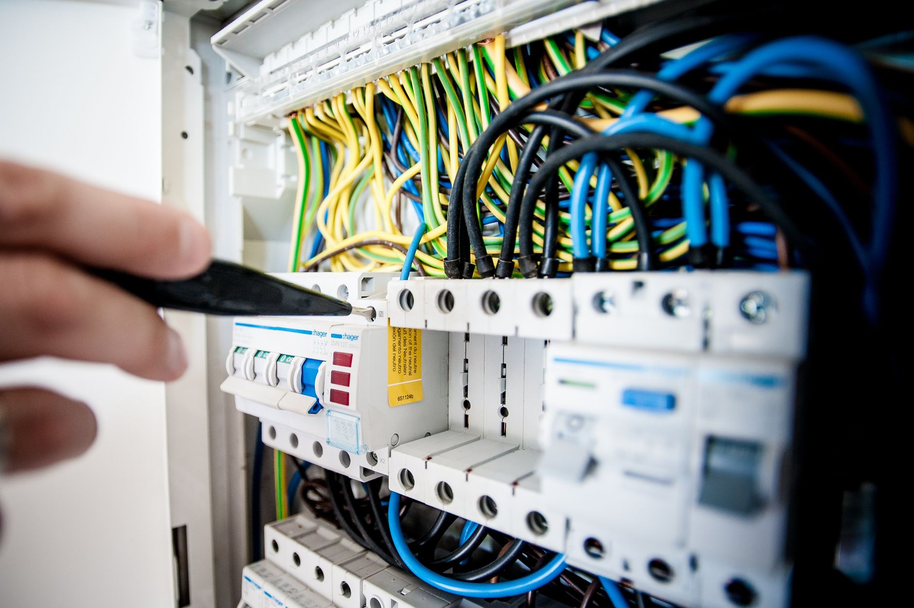 electrician hands connecting wires in fuse box