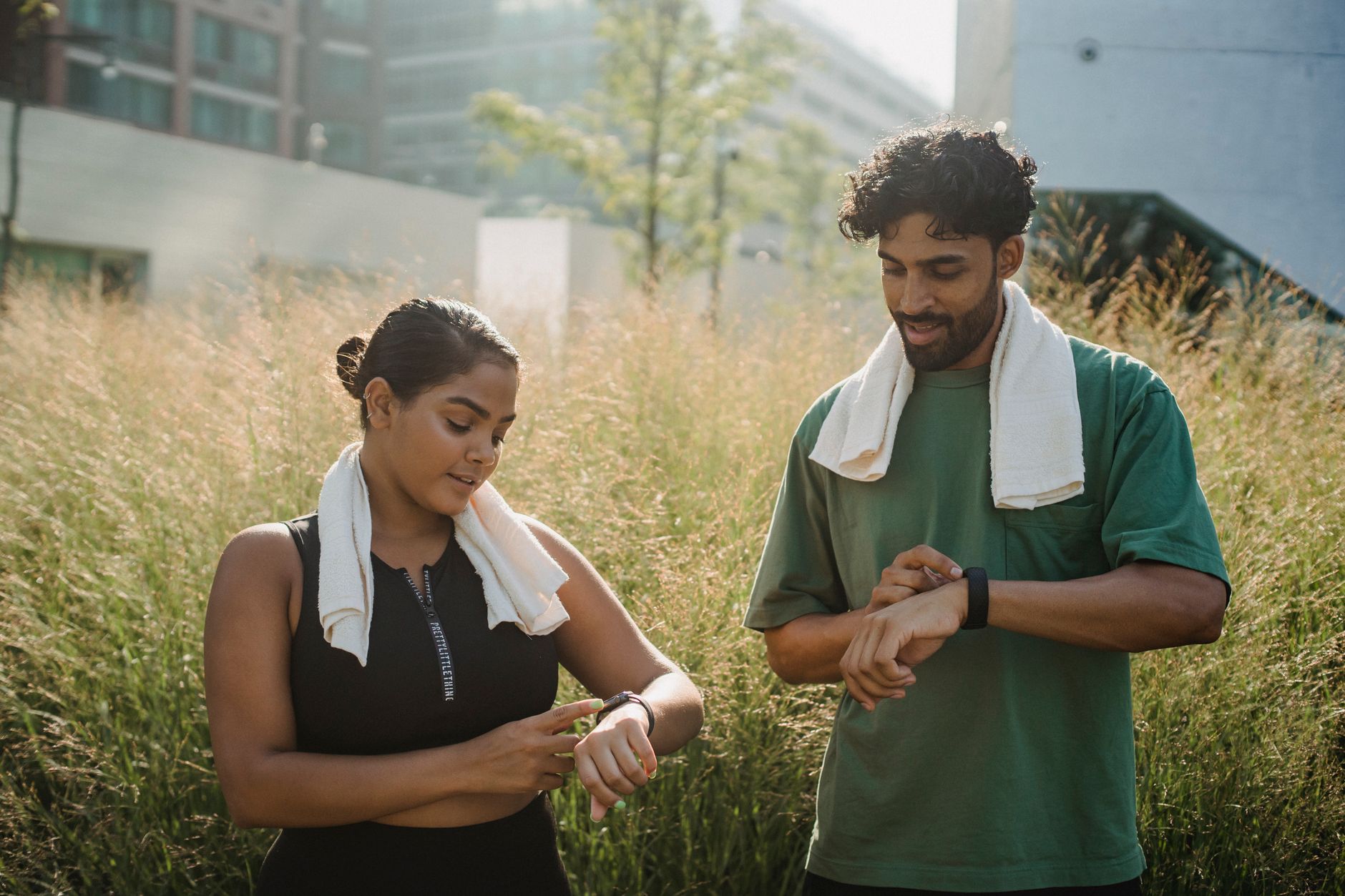 person jogging in park checking running app smartwatch