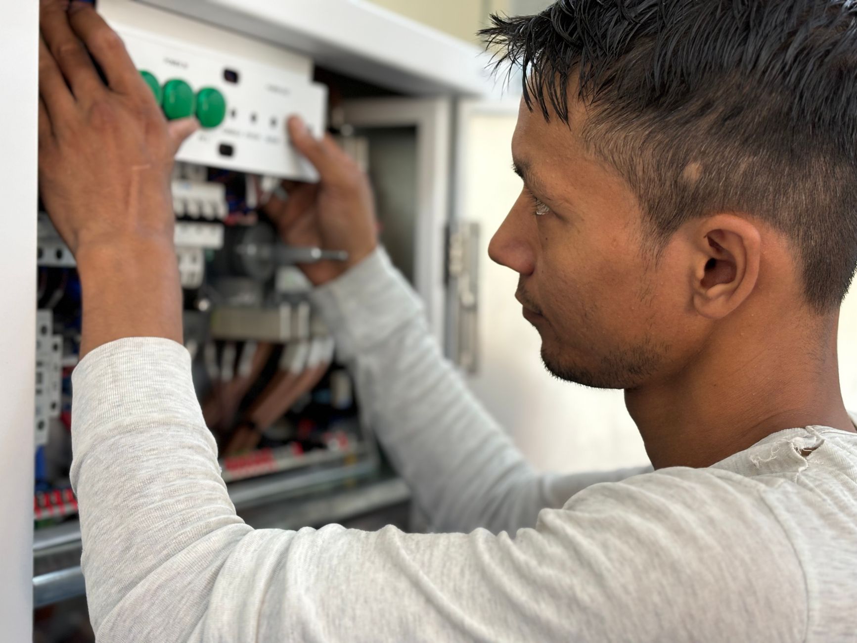 electrician hands connecting wires in fuse box