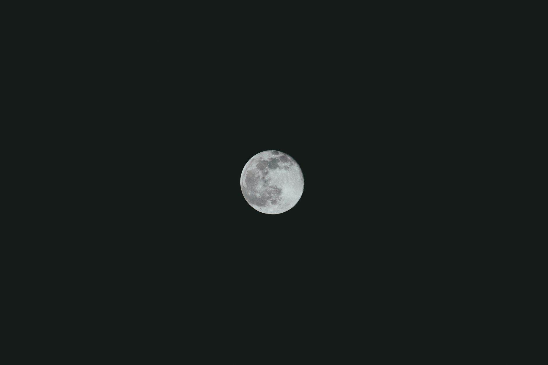 full moon shining brightly over dark landscape