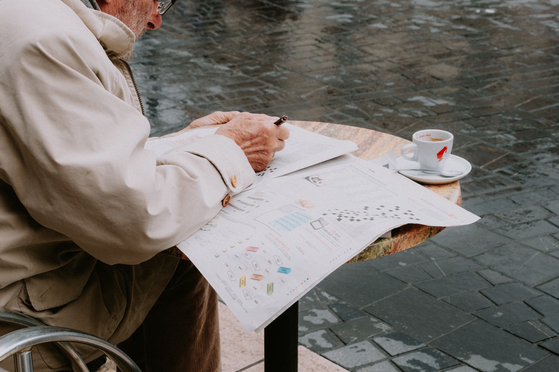 person reading newspaper at cafe table