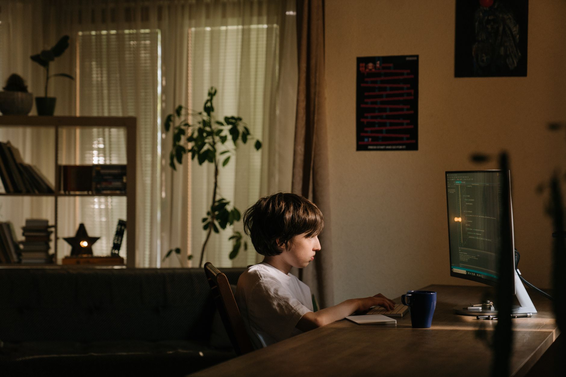 person coding on laptop in dim office light