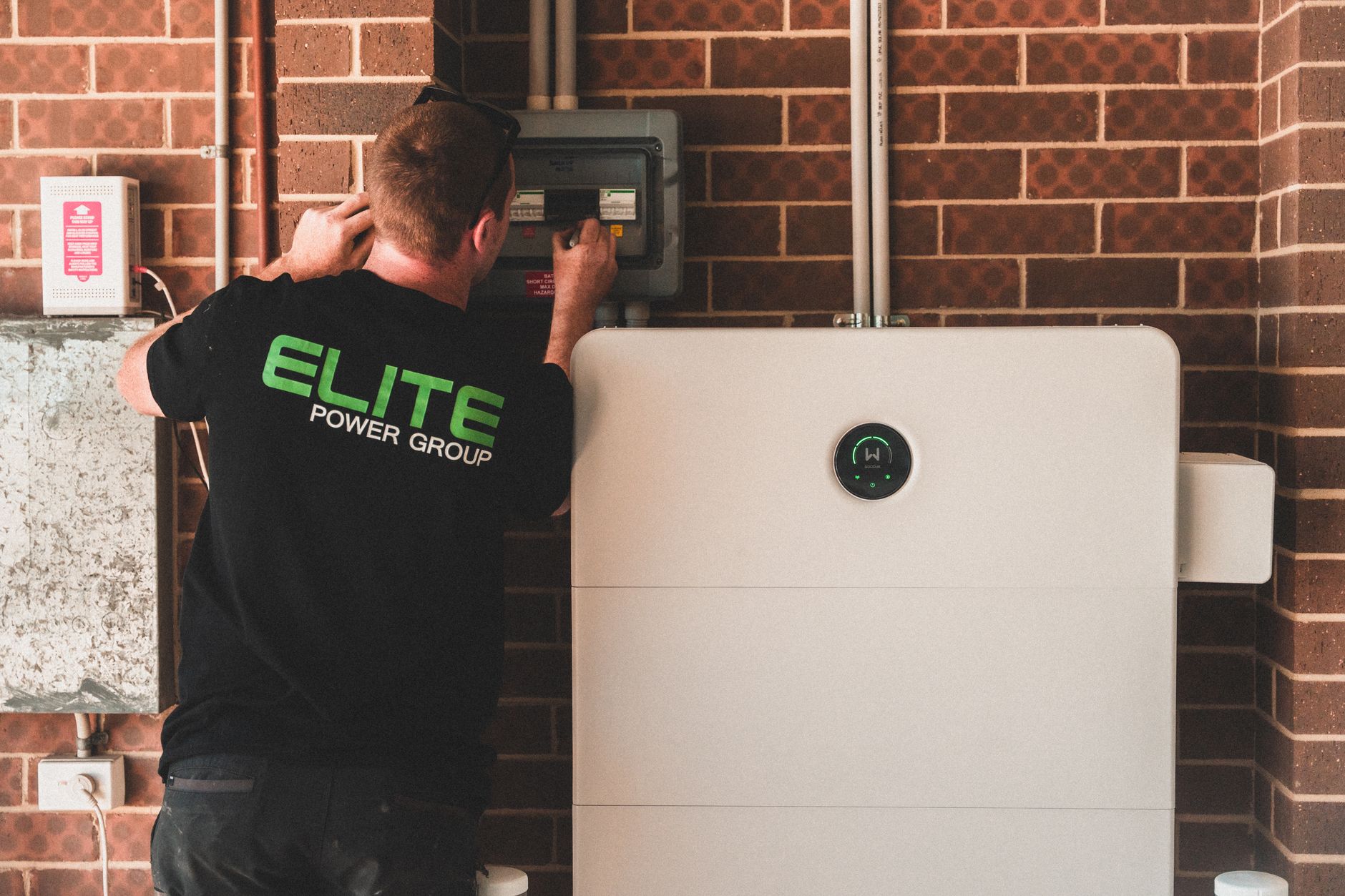 electrician inspecting home electricity panel with flashlight