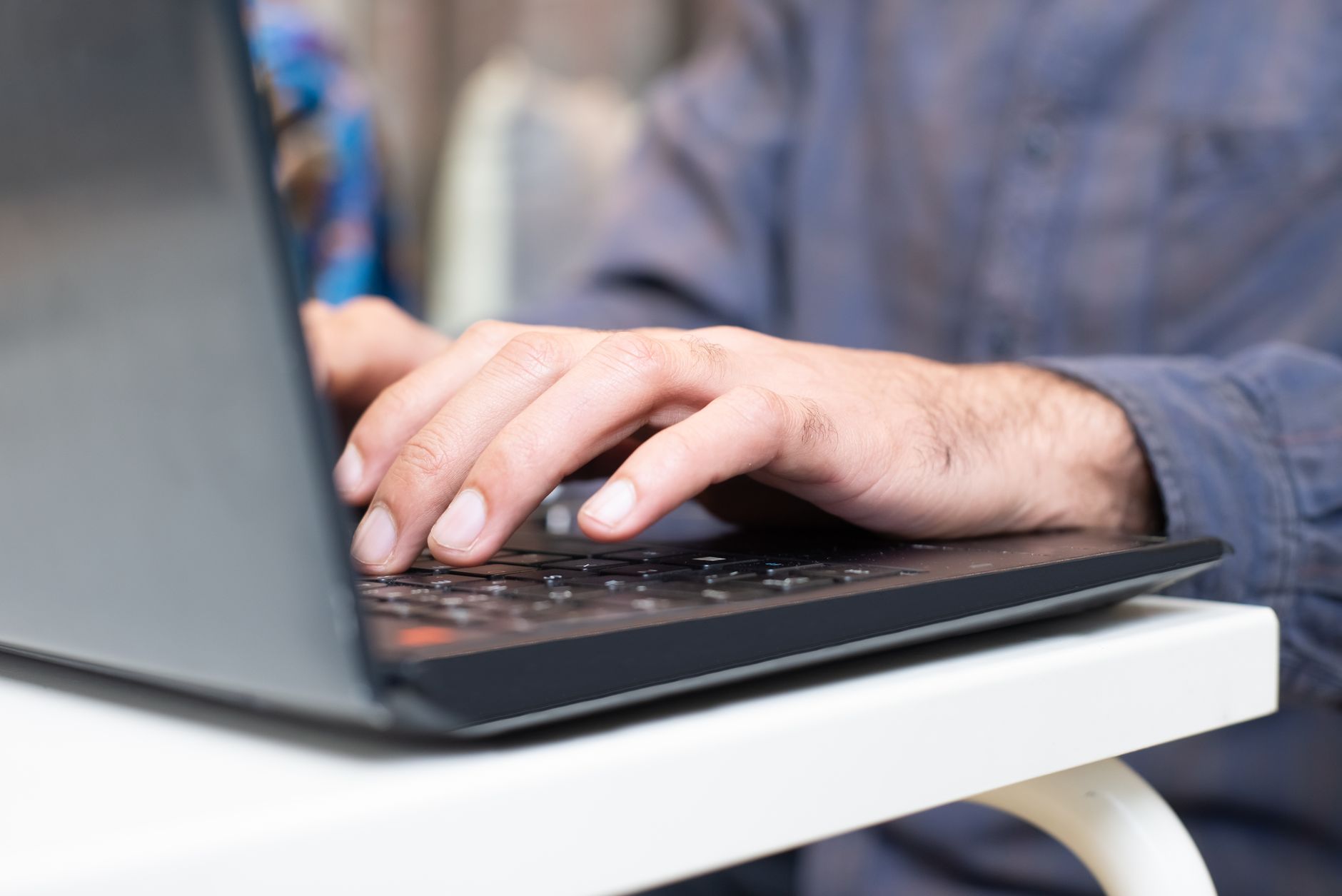 person hands typing on laptop in modern office