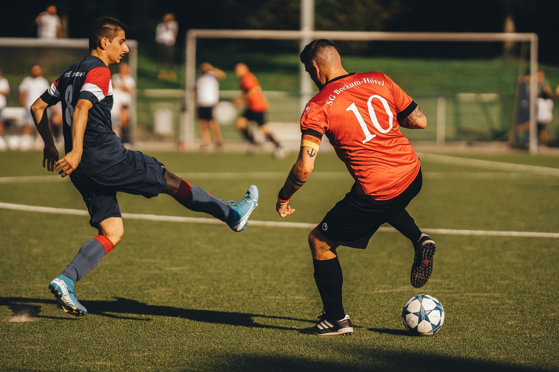 football players competing for ball on lush green field