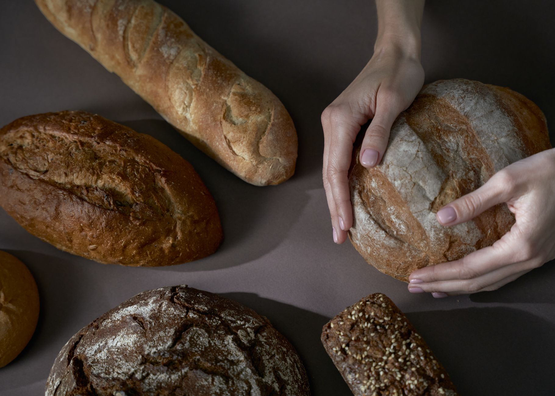 woman choosing whole wheat bread minimarket shelf