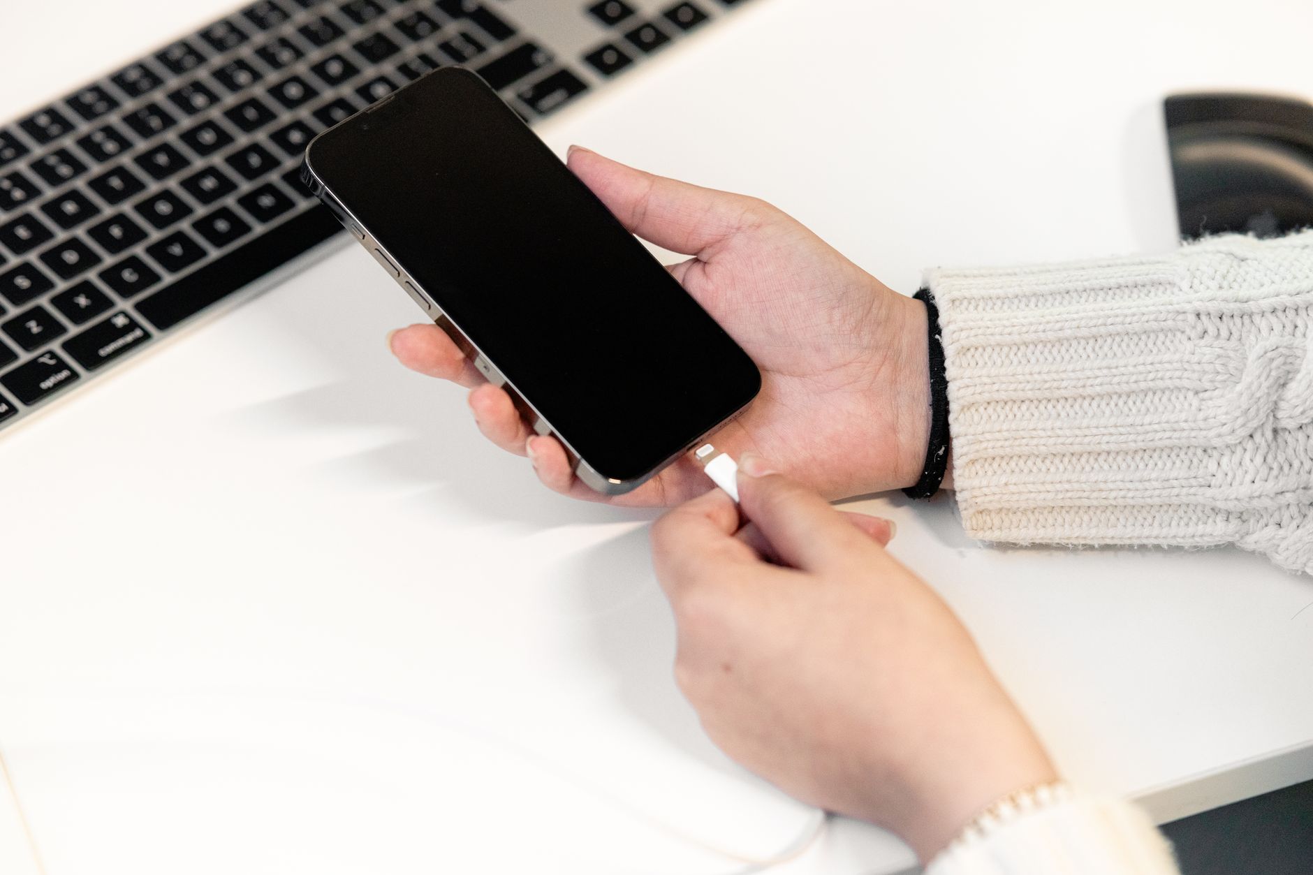 Hand holding android phone charging with cable