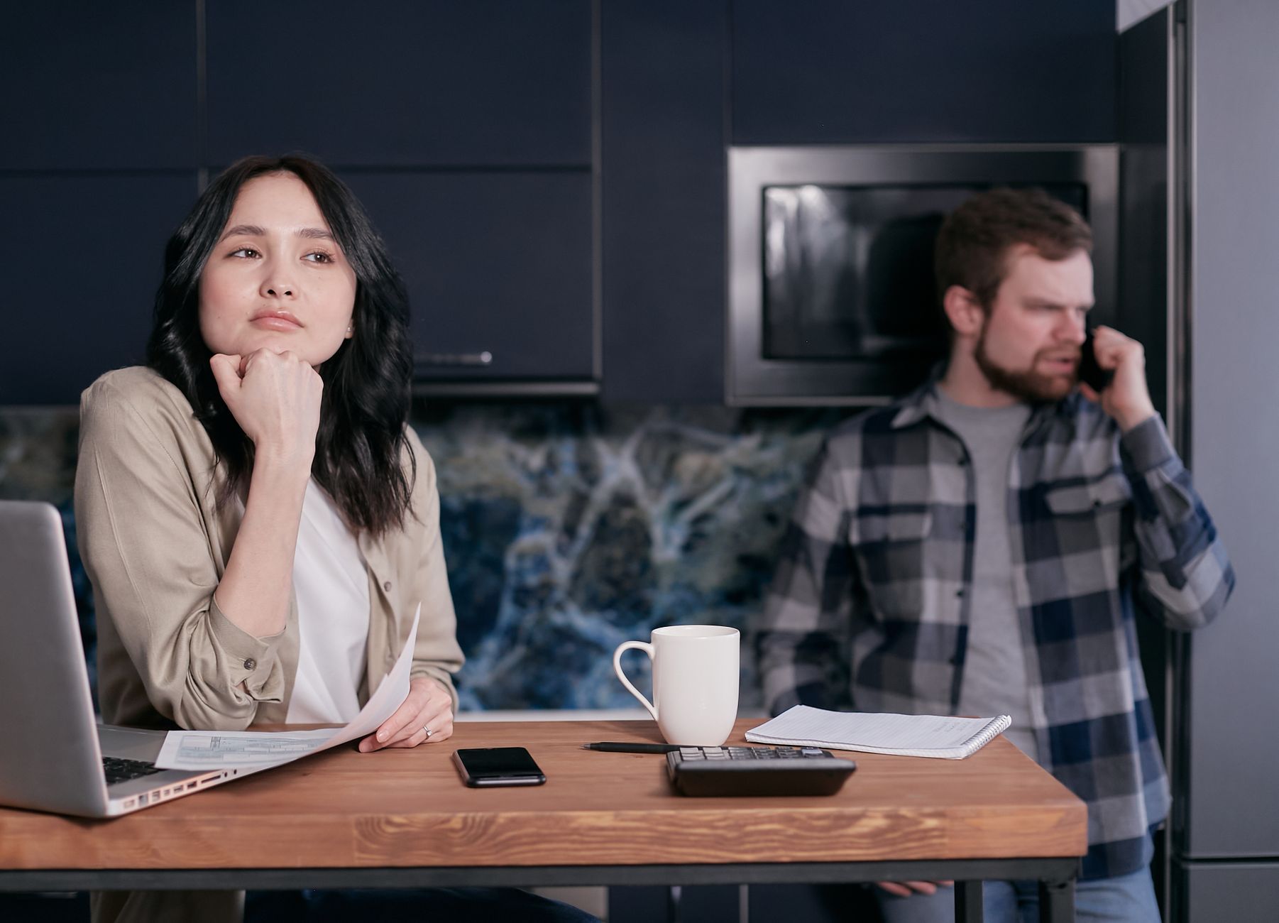 woman looking stressed at empty plate on table