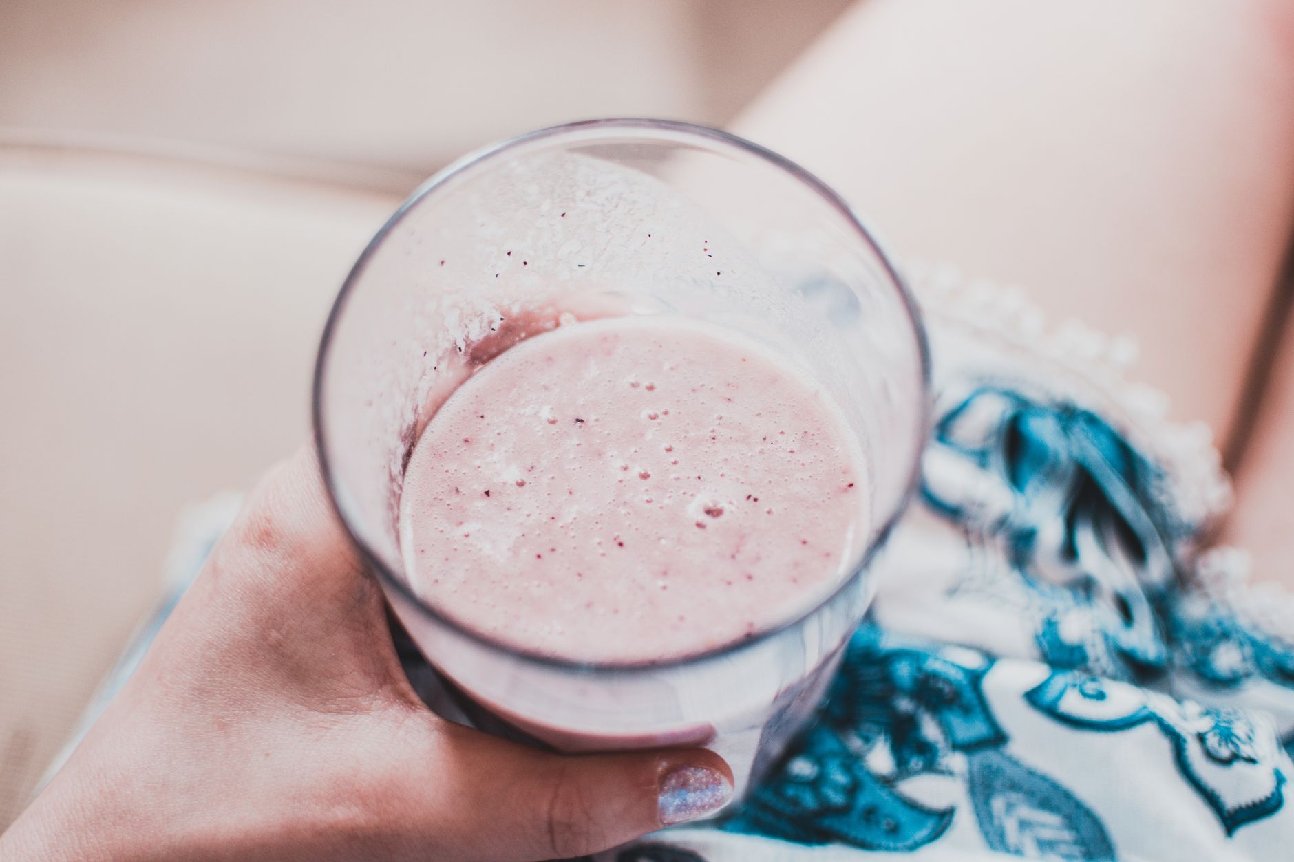 woman holding healthy fruit smoothie in kitchen