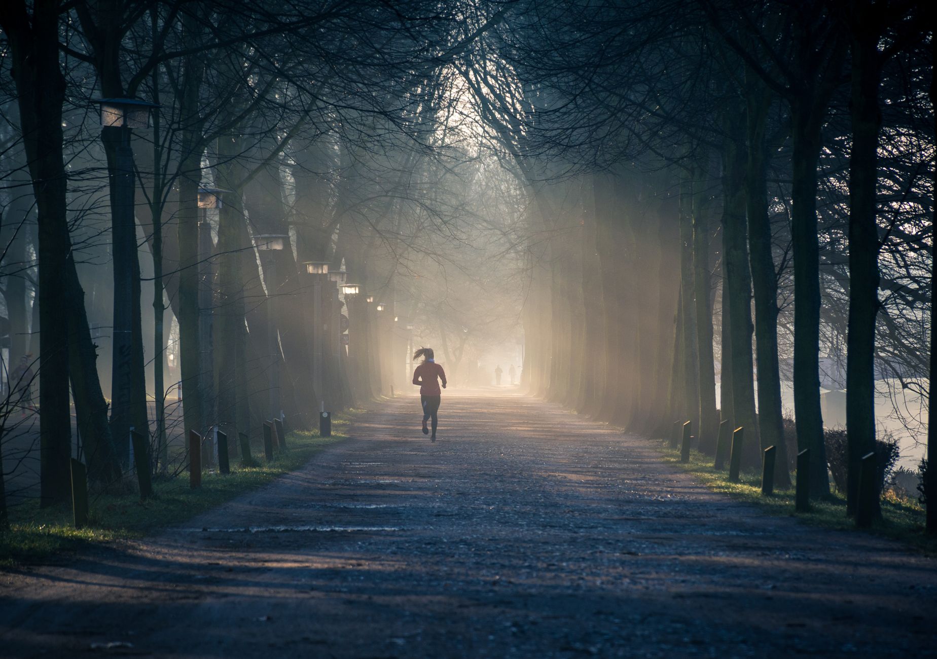 person jogging in green park early morning