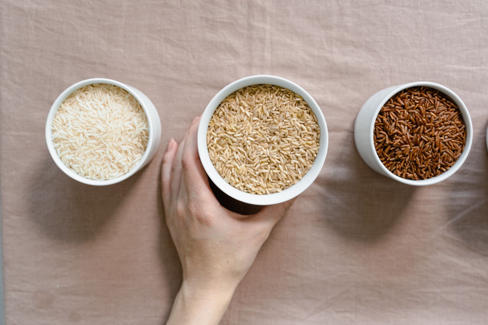 person examining rice grains on dark counter